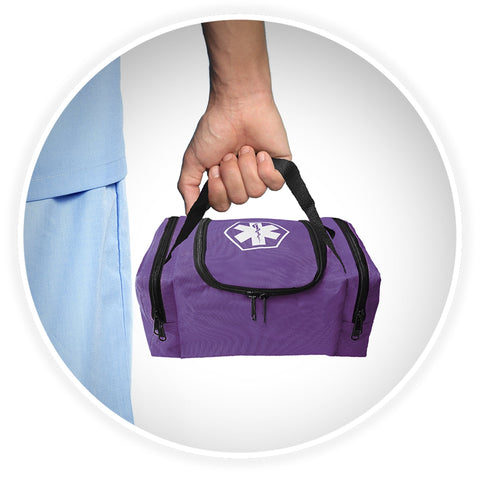 A shot of a person's hand holding the black webbed handle of the purple medical bag, demonstrating its portability against a background of someone wearing blue medical scrubs.