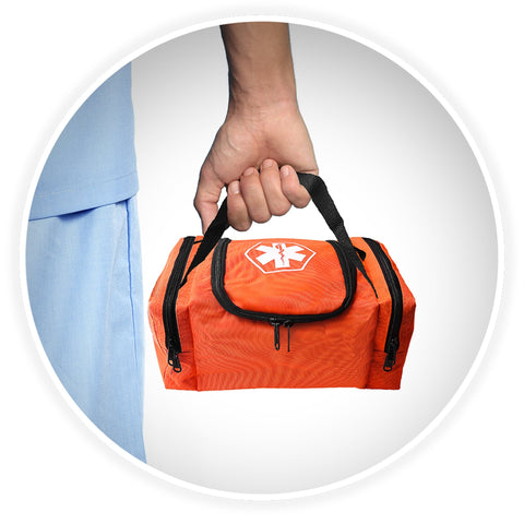 A shot of a person's hand holding the black webbed handle of the orange medical bag, demonstrating its portability against a background of someone wearing blue medical scrubs.