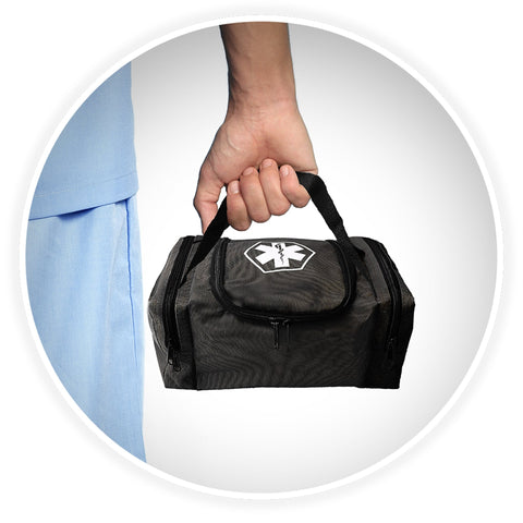 A shot of a person's hand holding the black webbed handle of the black medical bag, demonstrating its portability against a background of someone wearing blue medical scrubs.