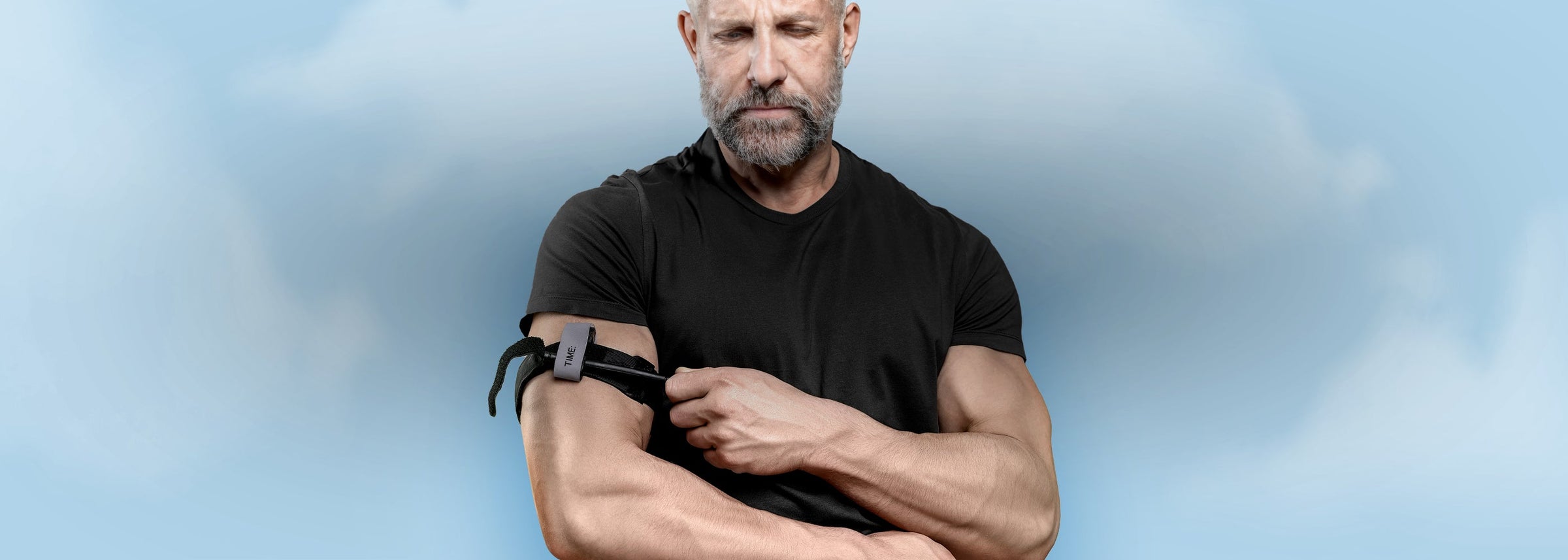 A man applying a black tactical medical tourniquet to his upper arm, representing the Tourniquets & Bleeding Control Kits collection.