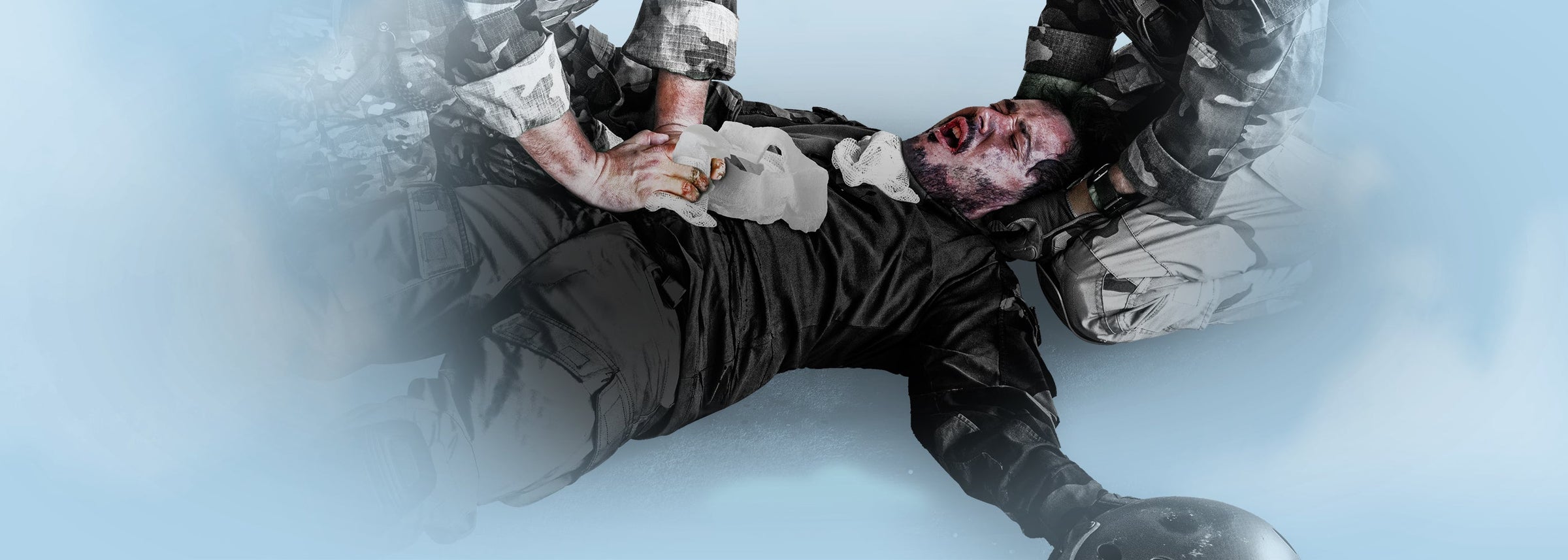 Emergency medical personnel applying a hemostatic dressing to a wounded individual, representing the Trauma Bandages & Hemostatic Dressings collection.