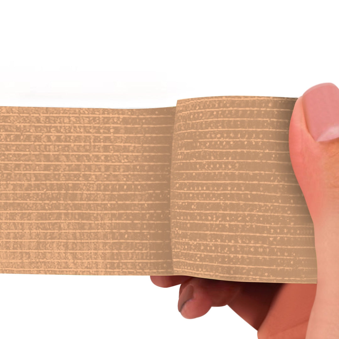 Tan adhesive bandage wrap held by a hand on a white background