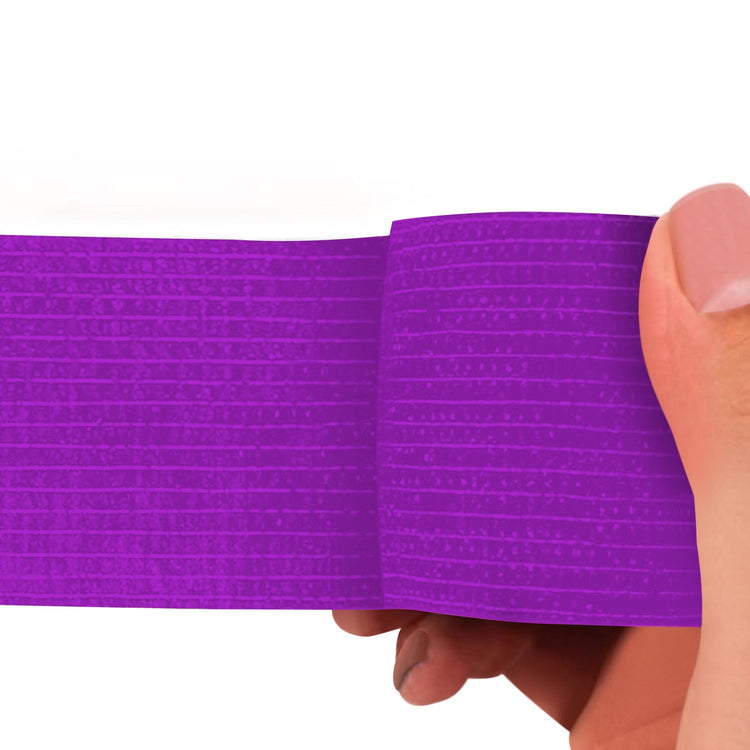 Purple adhesive bandage wrap held by a hand on a white background