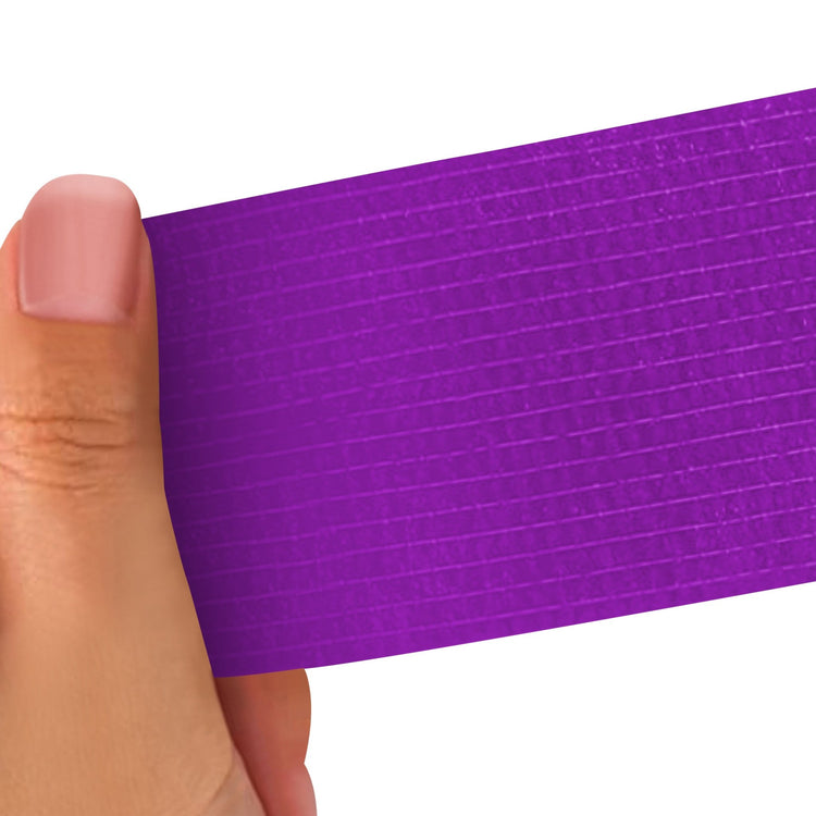 Hand holding a Purple strip of adhesive bandage wrap with a textured pattern on a white background