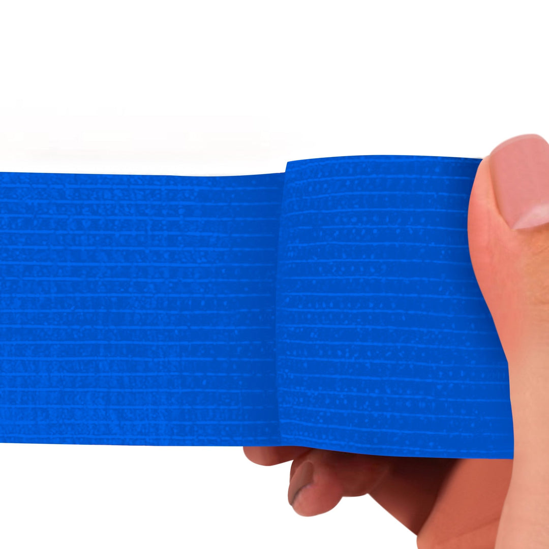 Blue adhesive bandage wrap held by a hand on a white background