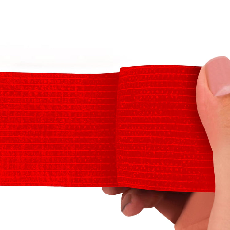 Red adhesive bandage wrap held by a hand on a white background