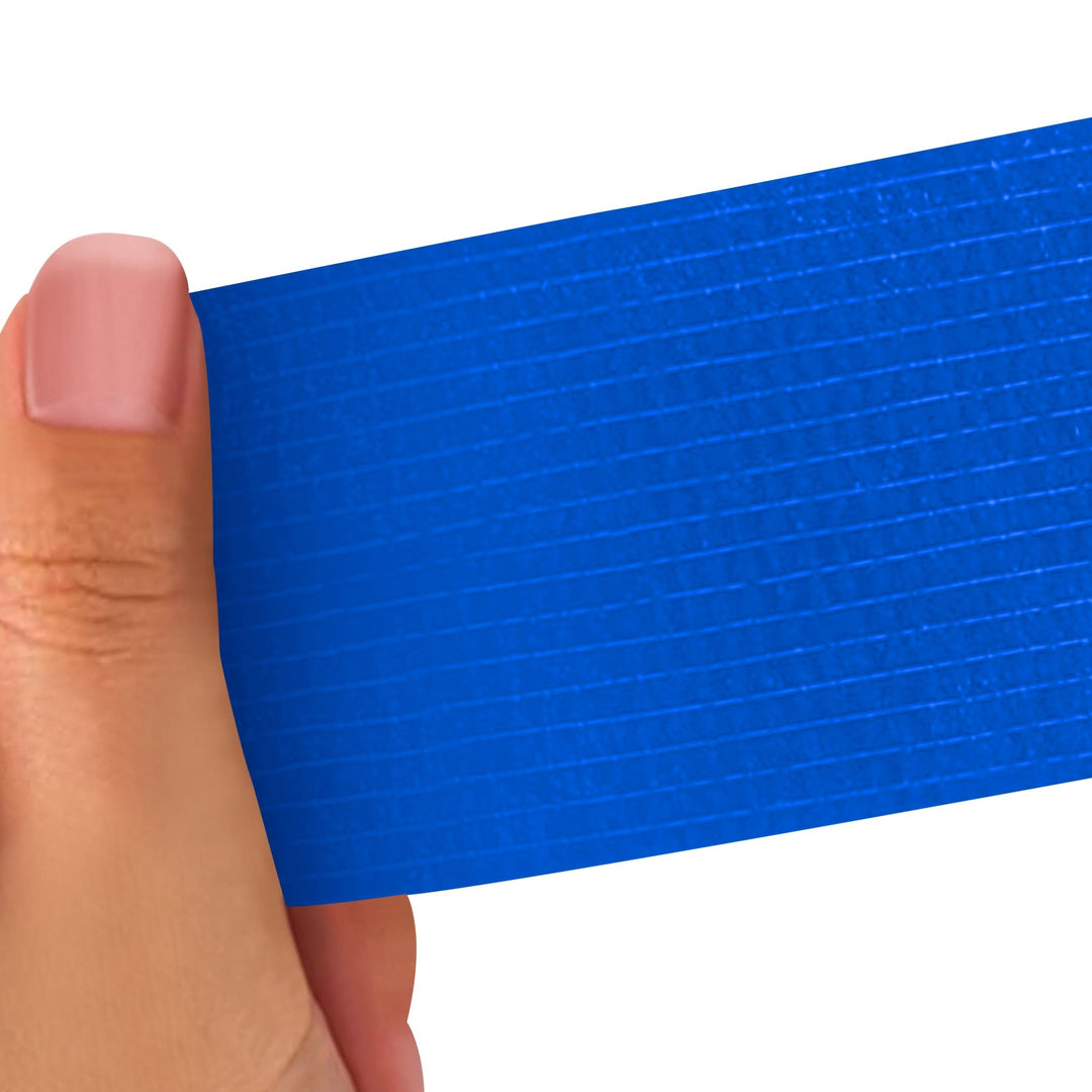 Hand holding a Blue strip of adhesive bandage wrap with a textured pattern on a white background
