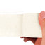 White adhesive bandage wrap held by a hand on a white background