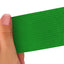 Hand holding a green strip of adhesive bandage wrap with a textured pattern on a white background