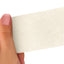 Hand holding a White strip of adhesive bandage wrap with a textured pattern on a white background