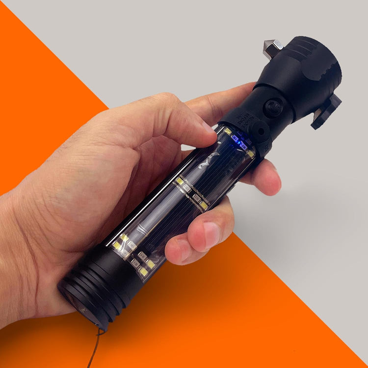 A person's hand holding the black tactical flashlight, showing the solar panel section and integrated side LEDs, with a slight blue light visible, suggesting it is charging or in use. The background is diagonally split orange and gray.