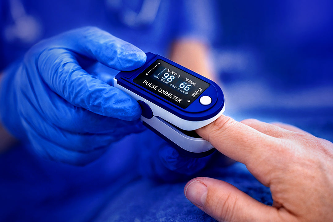 Close-up of a digital pulse oximeter on a patient's finger being checked by a medical professional, symbolizing precision medical equipment.