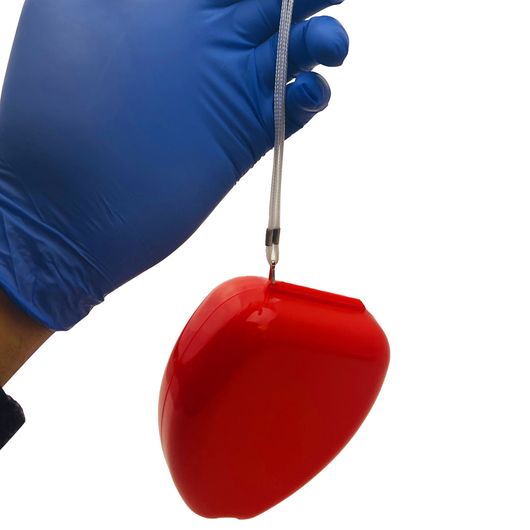 A hand wearing a blue nitrile glove holding a red CPR mask case suspended by its white wrist strap.