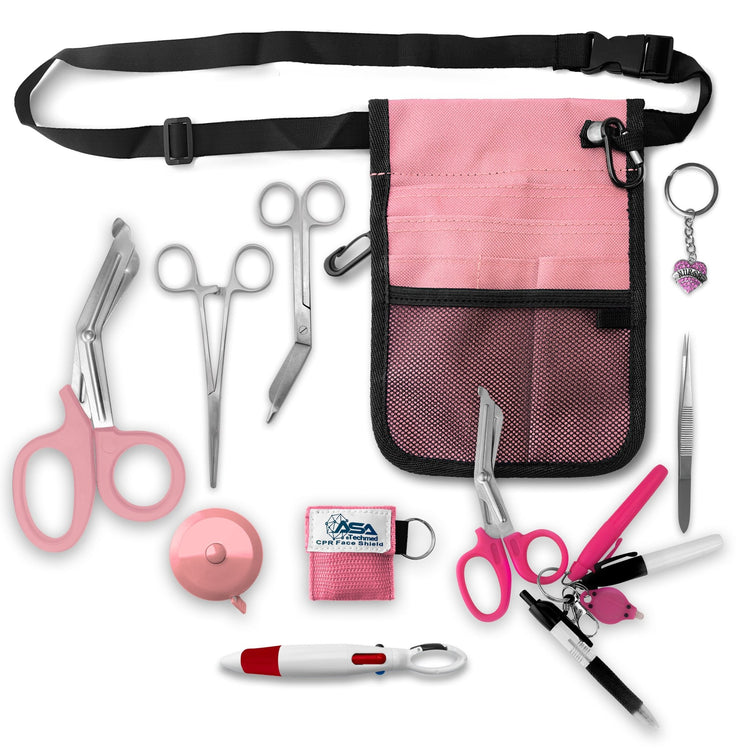 A top-down view displaying all items included in the kit laid out separately: the pink organizer pouch, adjustable black belt, large pink trauma shears, smaller bandage scissors, straight hemostats, pink tape measure, CPR face shield keychain, tweezers, a 4-color carabiner pen, permanent markers, and a rhinestone heart charm.
