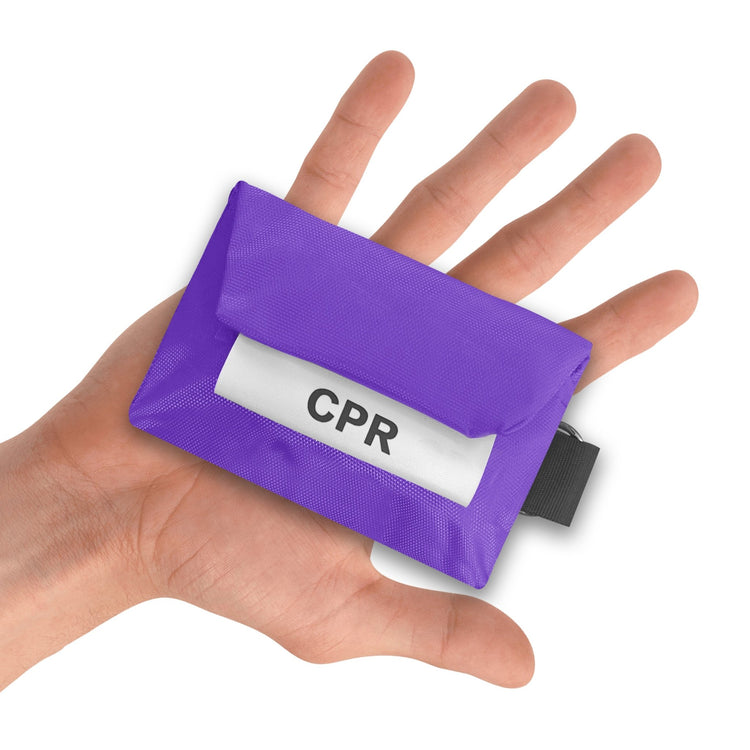 A purple CPR keychain pouch resting in the palm of an open hand to demonstrate its compact, portable size.