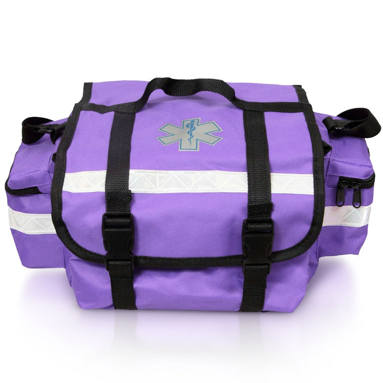 A straight-on front view of the purple EMT trauma bag. It features a central Star of Life symbol, two black straps with buckles securing the top flap, and a prominent reflective strip running horizontally across the front.
