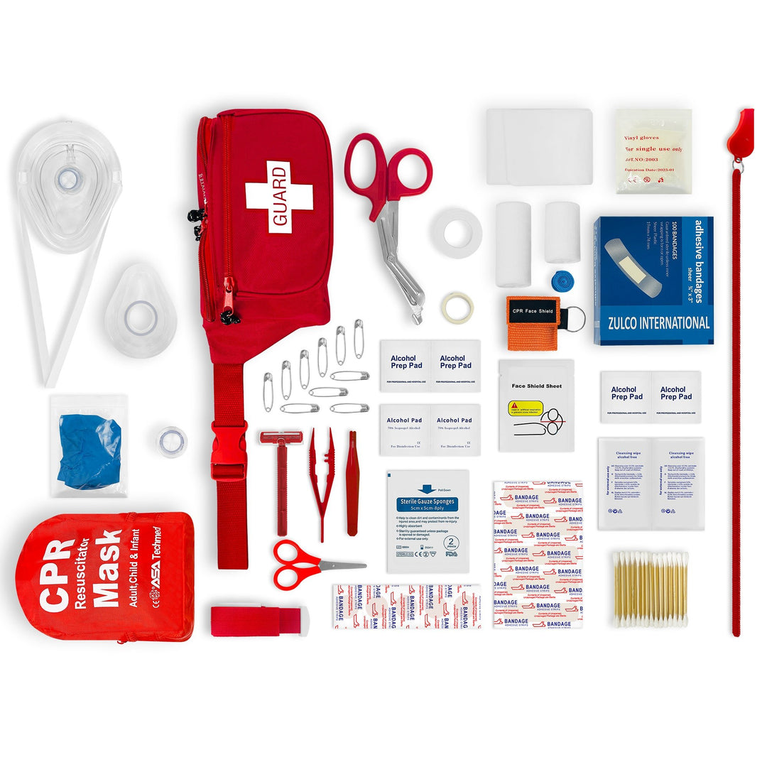 Organized flat lay of a red lifeguard first aid kit contents, including a "GUARD" fanny pack, CPR mask, trauma shears, bandages, gloves, and whistle.