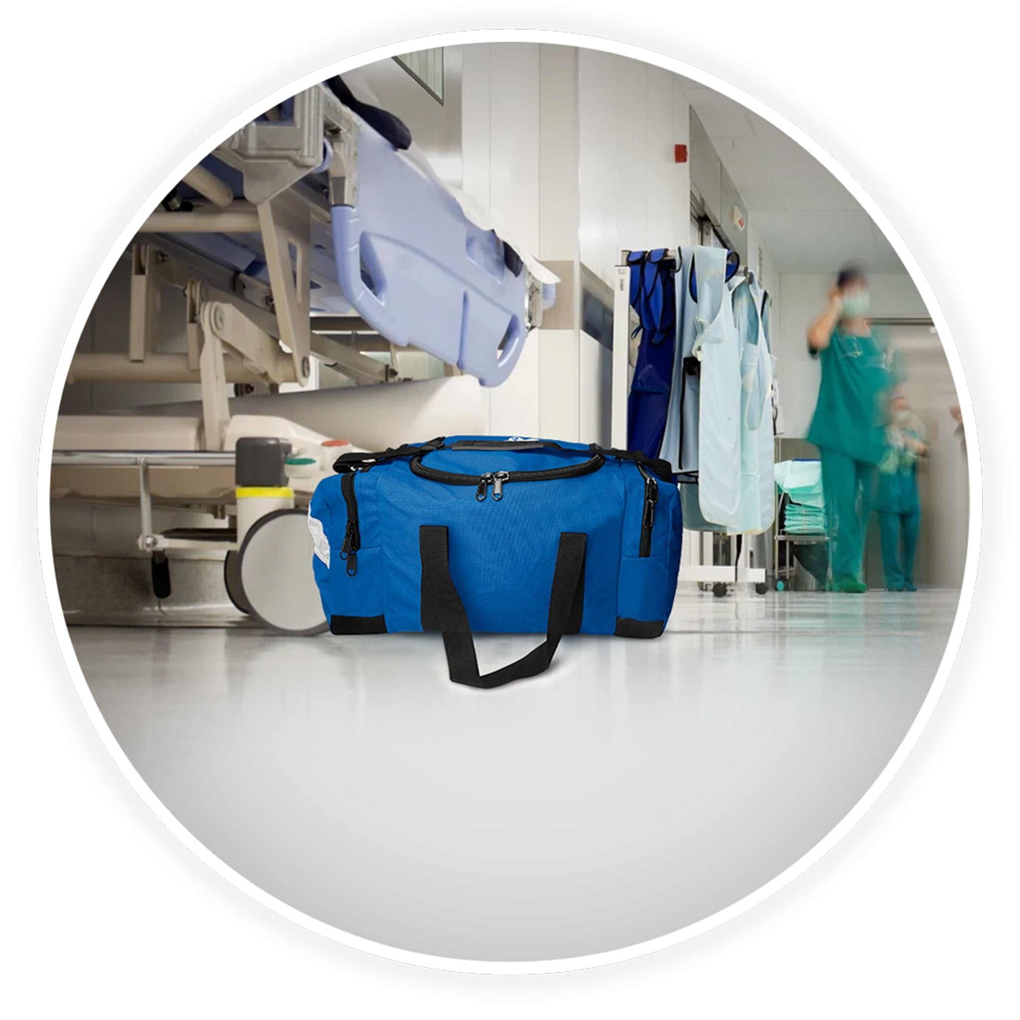 A blue emergency medical bag placed on the floor of a blurred hospital hallway, with a gurney and medical staff visible in the background.