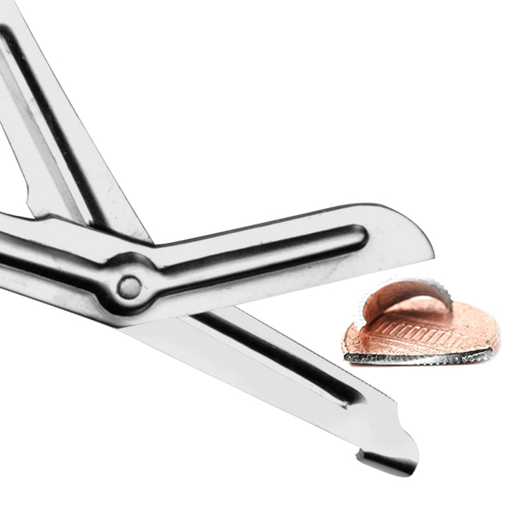 A close-up action shot showing the metal blades of the shears cutting through a copper penny, demonstrating the strength of the blades.