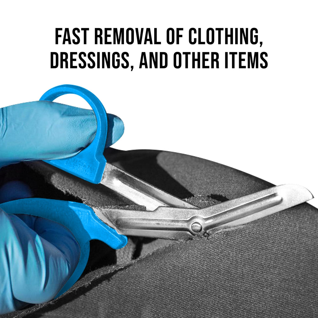 A pair of sea breeze shears held by blue-gloved hands cutting through thick black fabric. Text above reads, "FAST REMOVAL OF CLOTHING, DRESSINGS, AND OTHER ITEMS".