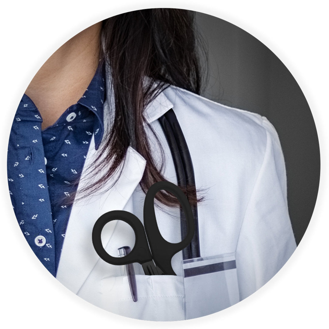 A close-up lifestyle image showing a medical professional in a white coat with a stethoscope, featuring black trauma shears tucked into their chest pocket.