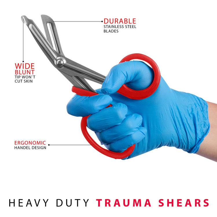 A hand wearing a blue medical glove holding red trauma shears, with text callouts pointing to the wide blunt safety tip, durable stainless steel blades, and ergonomic handle design.