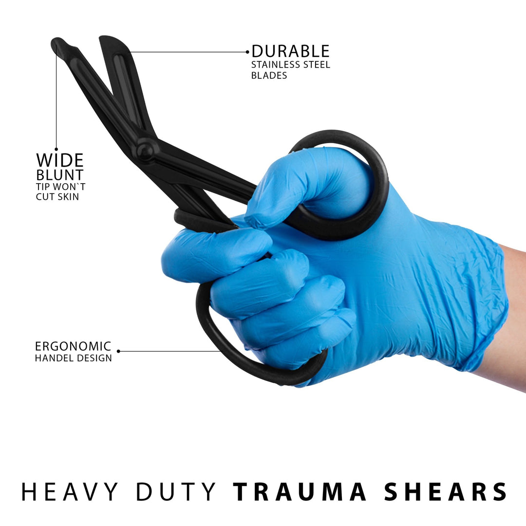 A hand wearing a blue medical glove holding black trauma shears, with text callouts pointing to the wide blunt safety tip, durable stainless steel blades, and ergonomic handle design.