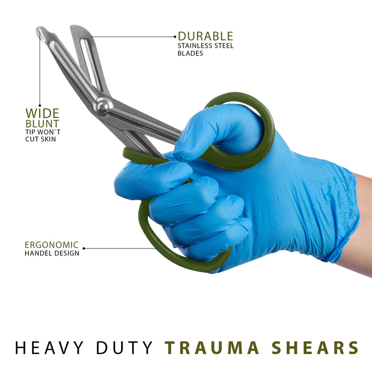 A hand wearing a blue medical glove holding green trauma shears, with text callouts pointing to the wide blunt safety tip, durable stainless steel blades, and ergonomic handle design.