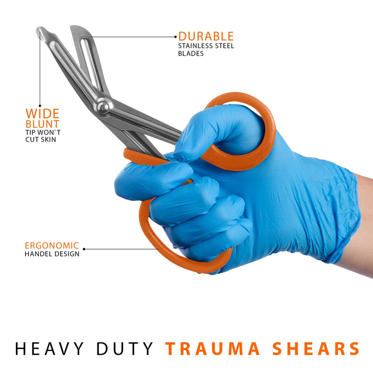 A hand wearing a blue medical glove holding orange trauma shears, with text callouts pointing to the wide blunt safety tip, durable stainless steel blades, and ergonomic handle design.