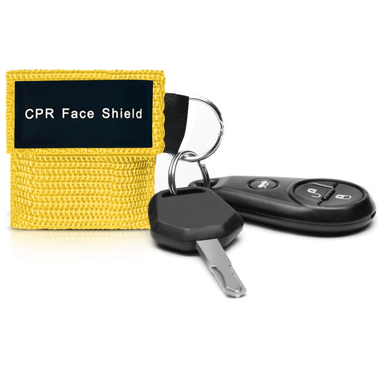 A close-up lifestyle shot of a yellow CPR face shield pouch attached to a car key fob, demonstrating its portability and convenience for everyday carry on a keyring.