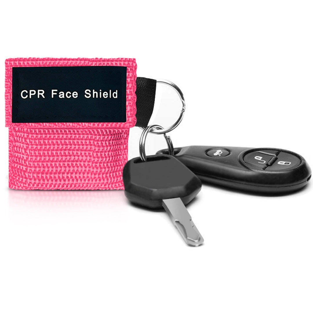 A close-up lifestyle shot of a pink CPR face shield pouch attached to a car key fob, demonstrating its portability and convenience for everyday carry on a keyring.
