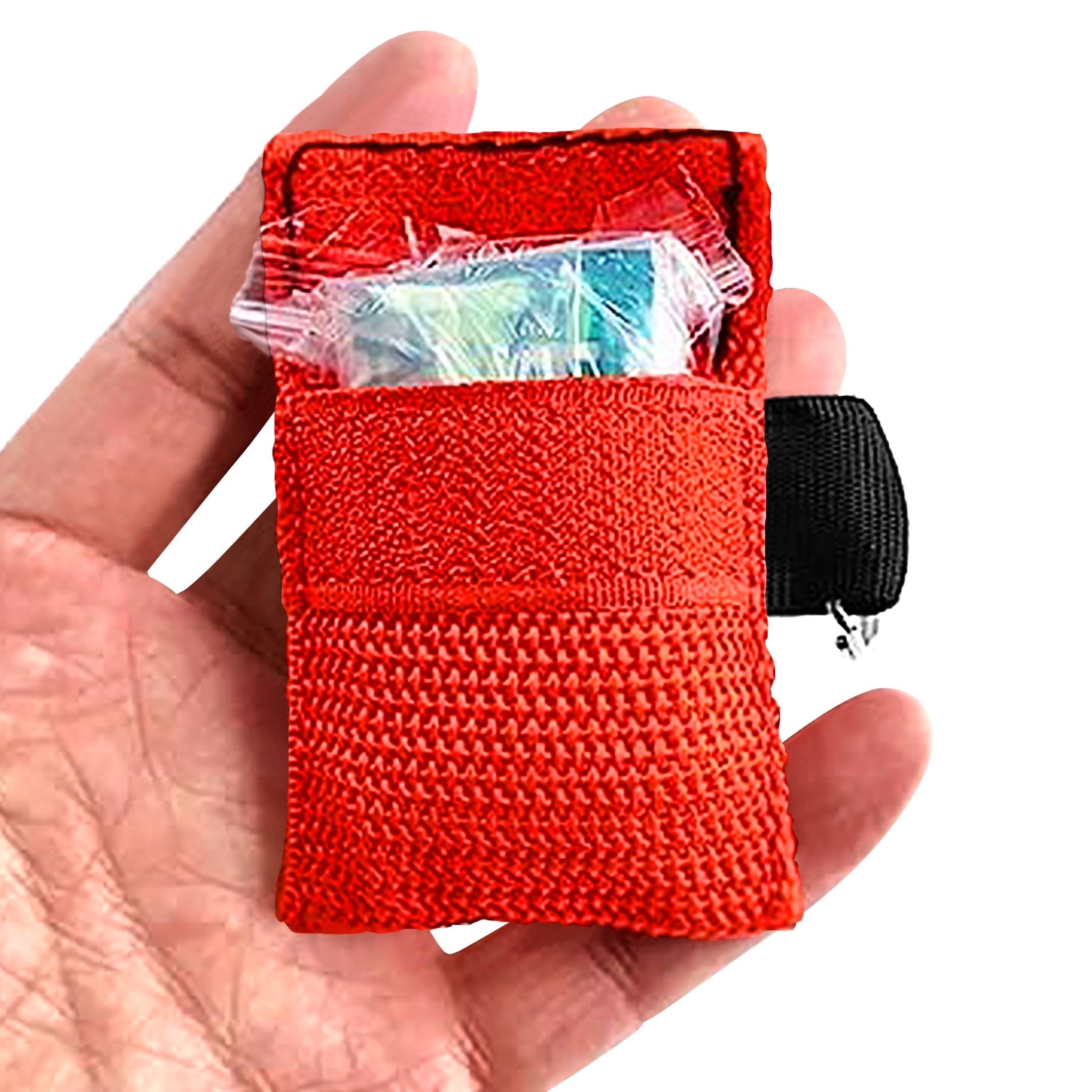 A hand holding an open red CPR face shield keychain pouch, revealing a clear plastic packet containing a face shield and gloves stored inside the front velcro pocket.