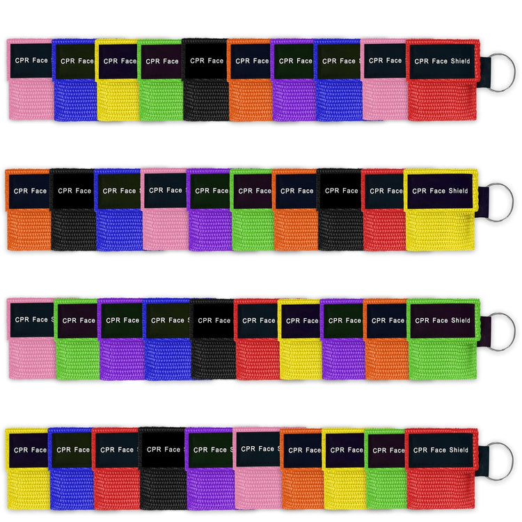 A display of a bulk assortment of CPR face shield keychains arranged in four rows, featuring various colors including pink, blue, yellow, green, black, orange, purple, and red.