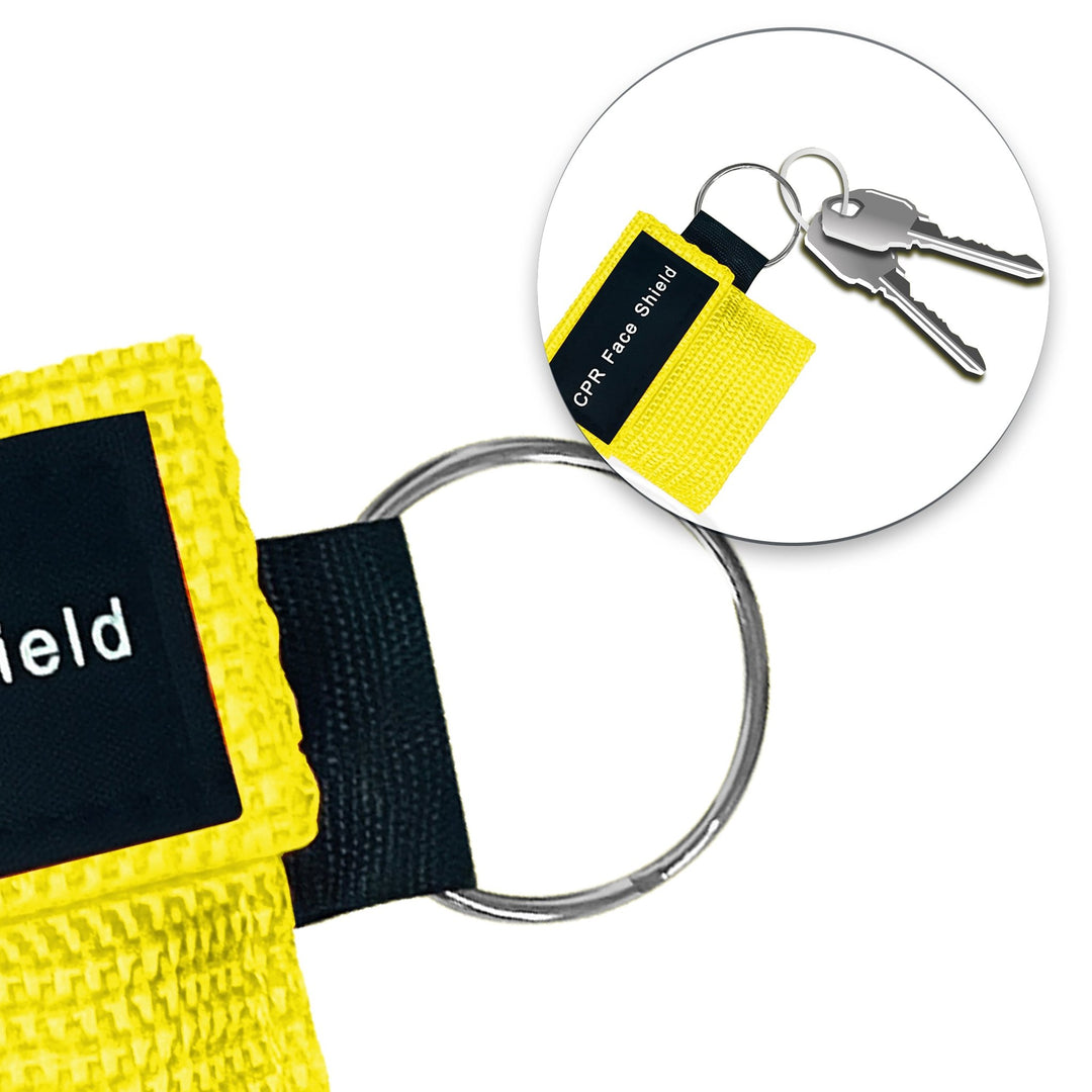 A lifestyle close-up showing a yellow CPR face shield pouch attached to a set of car keys, demonstrating its compact size and portability for everyday carry.