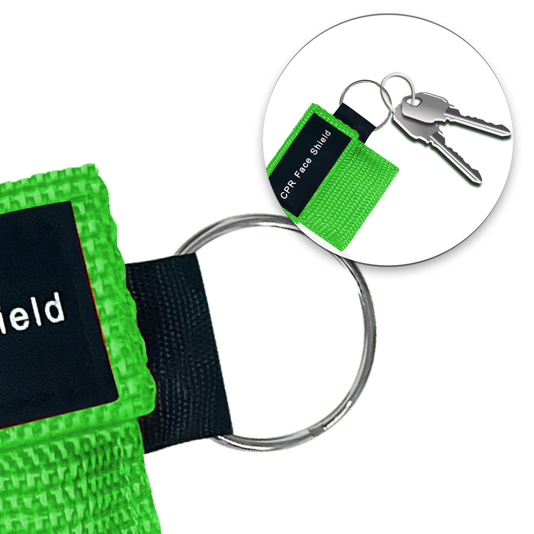 A lifestyle close-up showing a green CPR face shield pouch attached to a set of car keys, demonstrating its compact size and portability for everyday carry.