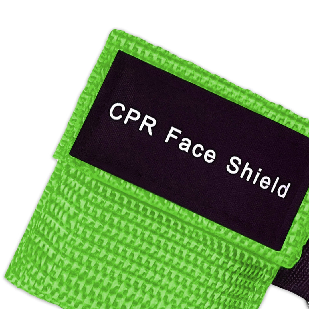 A top-down close-up view of a single green CPR keychain pouch, highlighting the woven fabric texture and the black identification label.