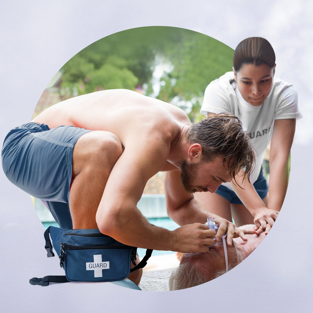 A lifestyle image of a male lifeguard performing CPR during a training scenario, with the blue "GUARD" fanny pack placed on the ground next to him for immediate access.