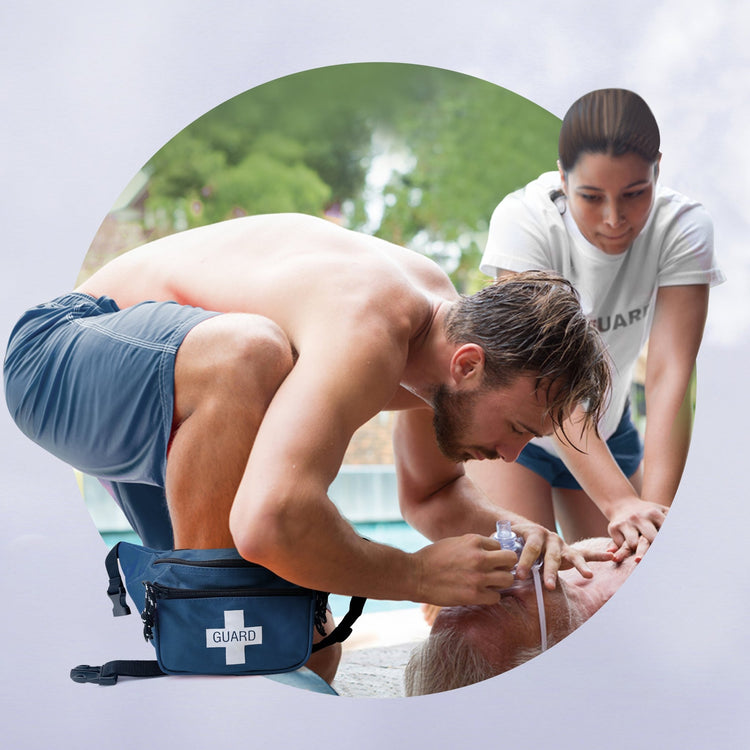 A lifestyle image of a male lifeguard performing CPR during a training scenario, with the blue "GUARD" fanny pack placed on the ground next to him for immediate access.