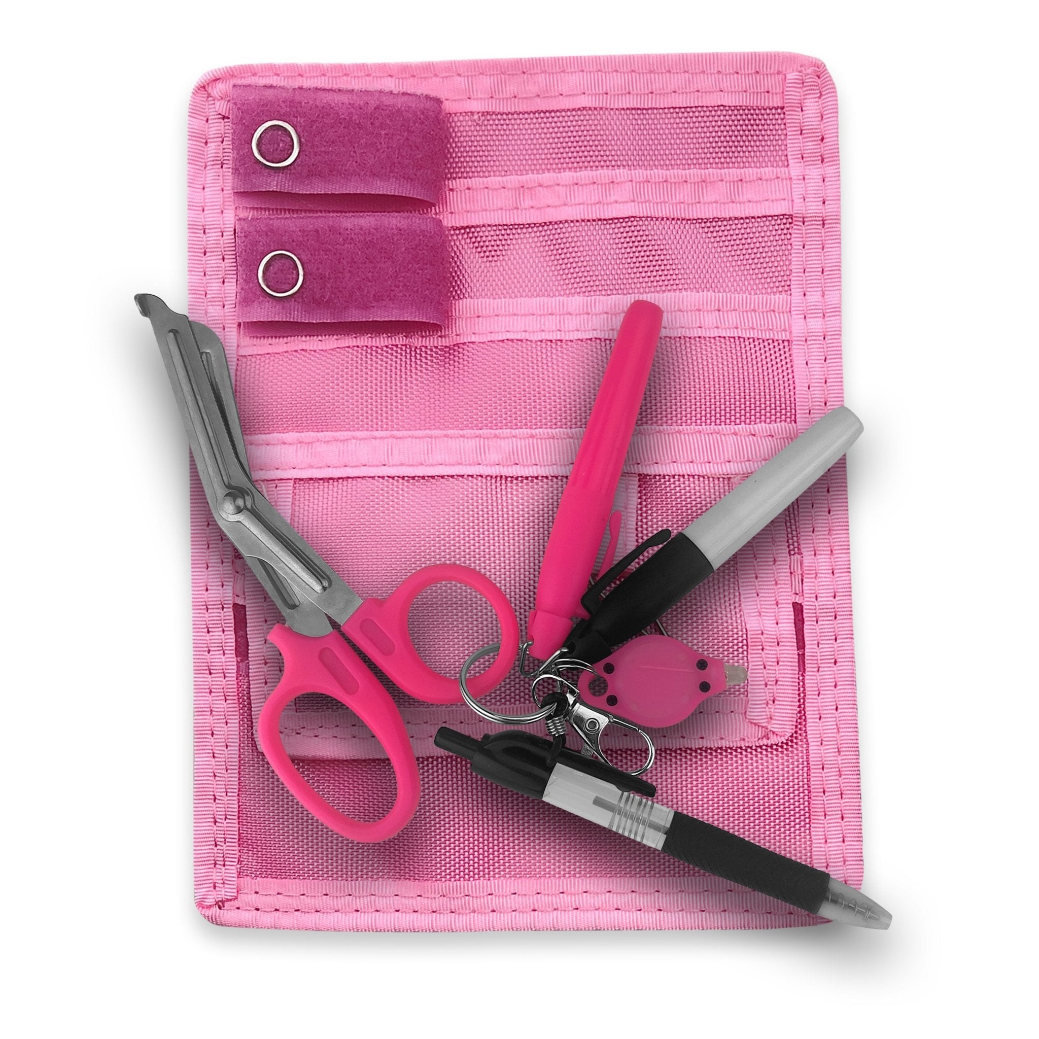 A flat-lay overview of the complete pink nursing kit. The set includes a pink nylon pocket protector pouch containing pink trauma shears, a pink disposable penlight, a pink keychain light, a black ink pen, a grey permanent marker, and a pink highlighter.