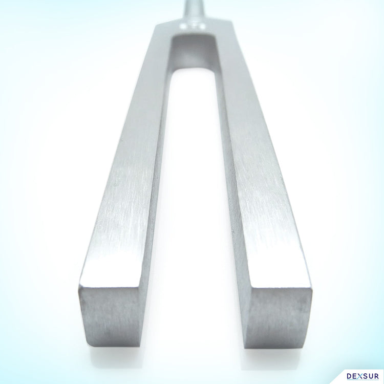 A detailed studio shot focusing on the distal end of the C512 tuning fork prongs. The image provides a low-angle perspective looking up between the two parallel silver aluminum prongs.