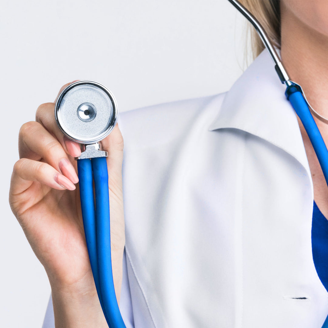A lifestyle shot of a healthcare worker in a white lab coat holding the sea breeze stethoscope’s chest piece forward as if ready to examine a patient.