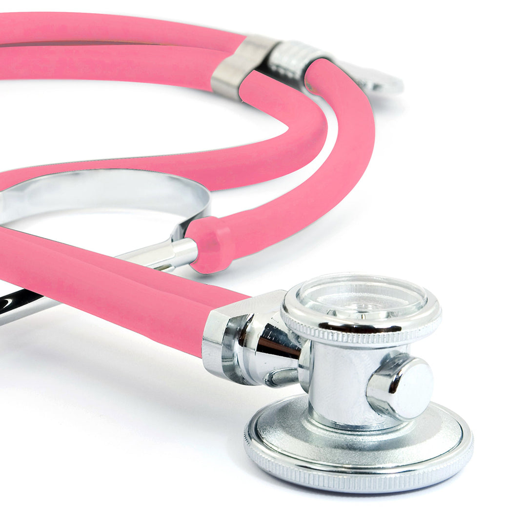 A macro close-up focusing on the rotatable chrome chest piece of the frosted pink stethoscope. It clearly shows the diaphragm side used for high-frequency sounds and the bell side used for low-frequency sounds.
