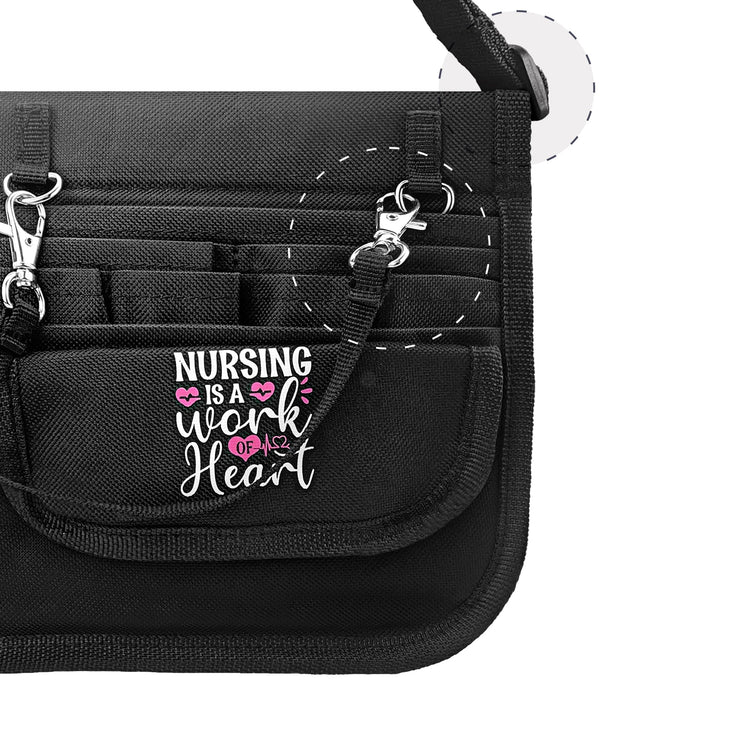 Close-up detail of the front flap featuring the inspiring text 'NURSING IS A WORK OF HEART' in pink and white, alongside a metal accessory clip.