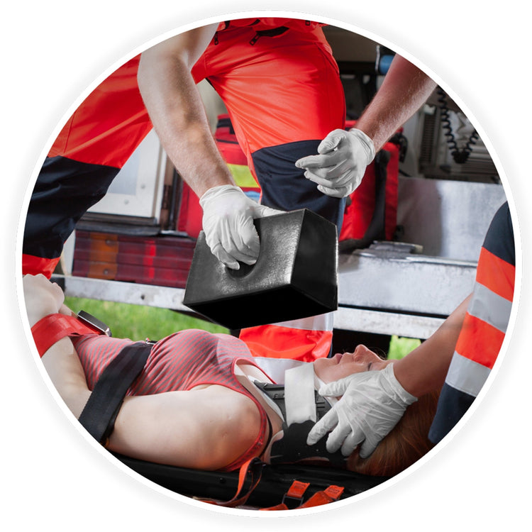 Emergency medical responders in action securing a patient to the spine board using head immobilizer blocks and straps during a rescue.