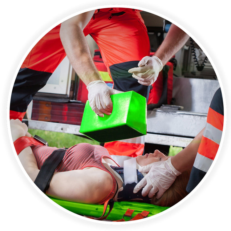 Emergency medical responders in action securing a patient to the spine board using head immobilizer blocks and straps during a rescue.