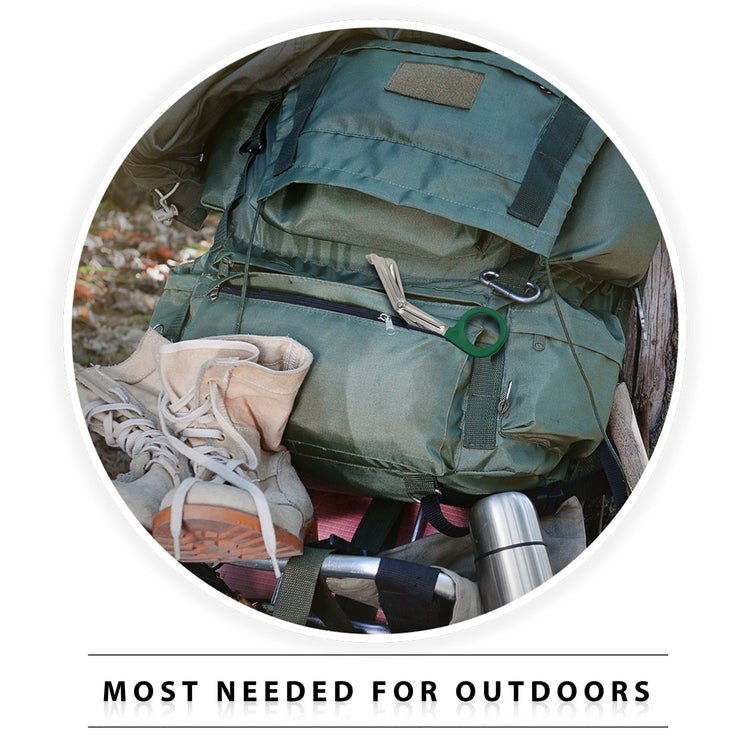 A lifestyle image titled "MOST NEEDED FOR OUTDOORS" showing hiking gear. A pair of Hunter green-handled trauma shears is tucked into the zippered pocket of a green hiking backpack, which sits next to tan boots and a stainless steel flask, illustrating the tool's utility for outdoor survival.