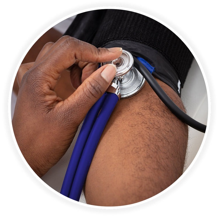 A close-up photo demonstrating a medical examination. A dark-skinned healthcare professional's hand is shown using the blue stethoscope to check a patient's blood pressure, placing the chest piece against the arm just below a black blood pressure cuff.