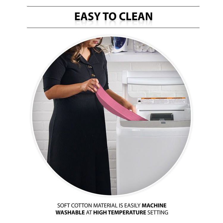 An instructional lifestyle image titled "EASY TO CLEAN." A woman is shown standing in a laundry room, placing the pink gait belt into a white top-loading washing machine. Text at the bottom highlights the care instructions: "SOFT COTTON MATERIAL IS EASILY MACHINE WASHABLE AT HIGH TEMPERATURE SETTING."