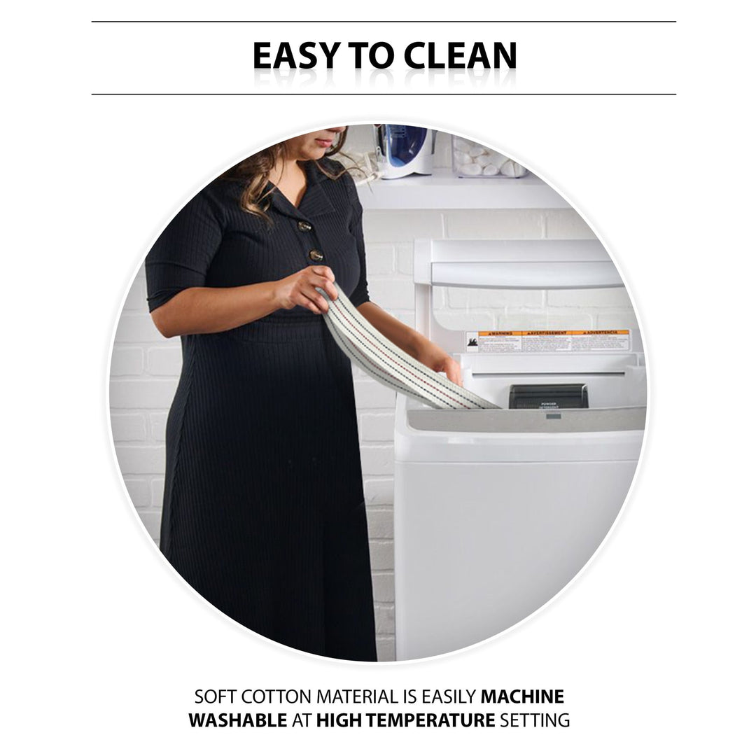 An instructional lifestyle image titled "EASY TO CLEAN." A woman is shown standing in a laundry room, placing the beige gait belt into a white top-loading washing machine. Text at the bottom highlights the care instructions: "SOFT COTTON MATERIAL IS EASILY MACHINE WASHABLE AT HIGH TEMPERATURE SETTING."