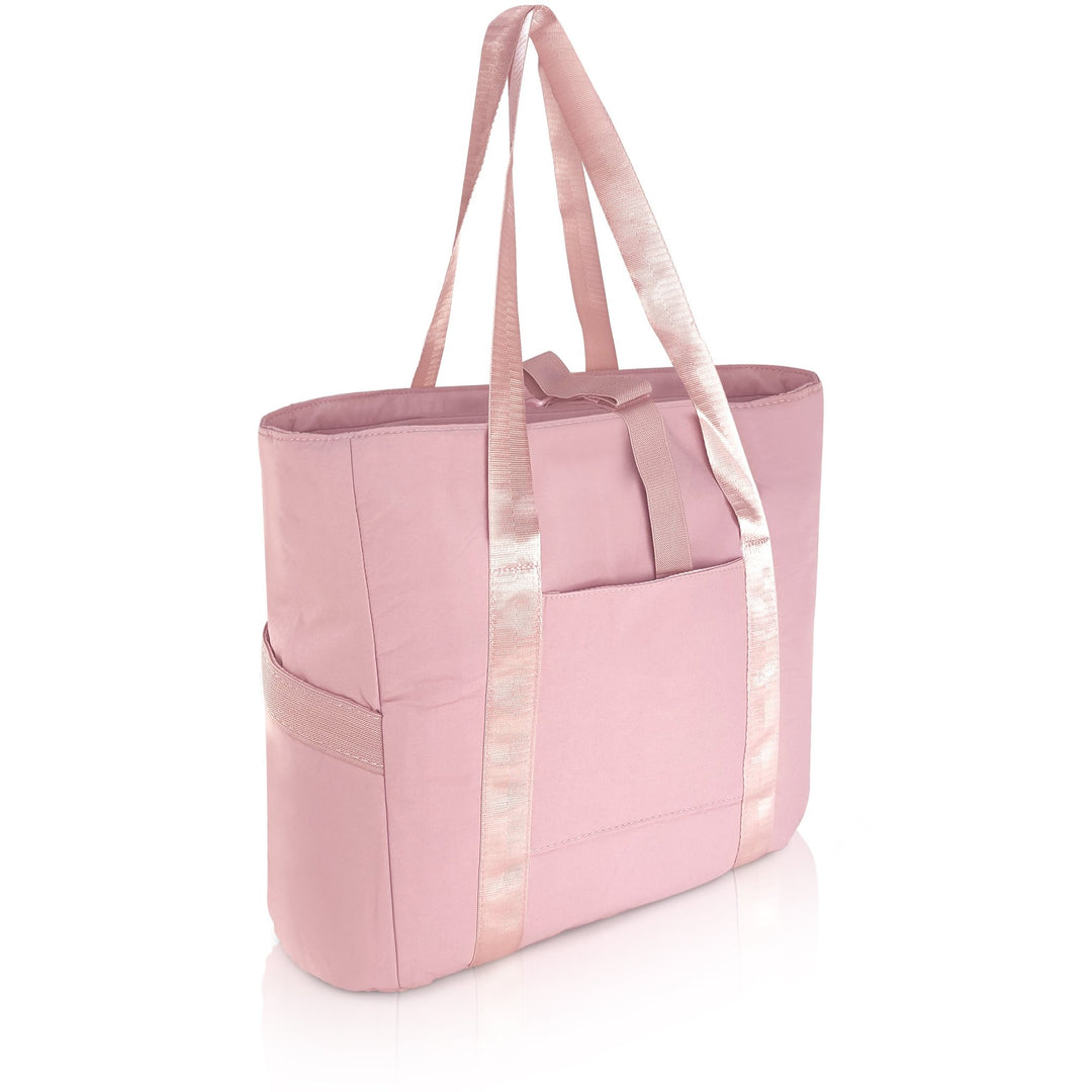 A 3/4 angle studio shot of the empty light pink tote bag against a white background. The image displays the dual shoulder straps, the front slip pocket, and the side elastic pockets.